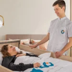 Zorgverlener bij patiënt in ziekenhuisbed met Turn All wisselligging systeem, automatisch draaien ter preventie van decubitus