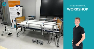 Workshop aan de Hanze. Op de Afbeelding is links afgebeeld een bed met een TurnAid en de voetbediening van de TurnAid. Achter het bed staat een Soqqie en een poster van ATO FORM.