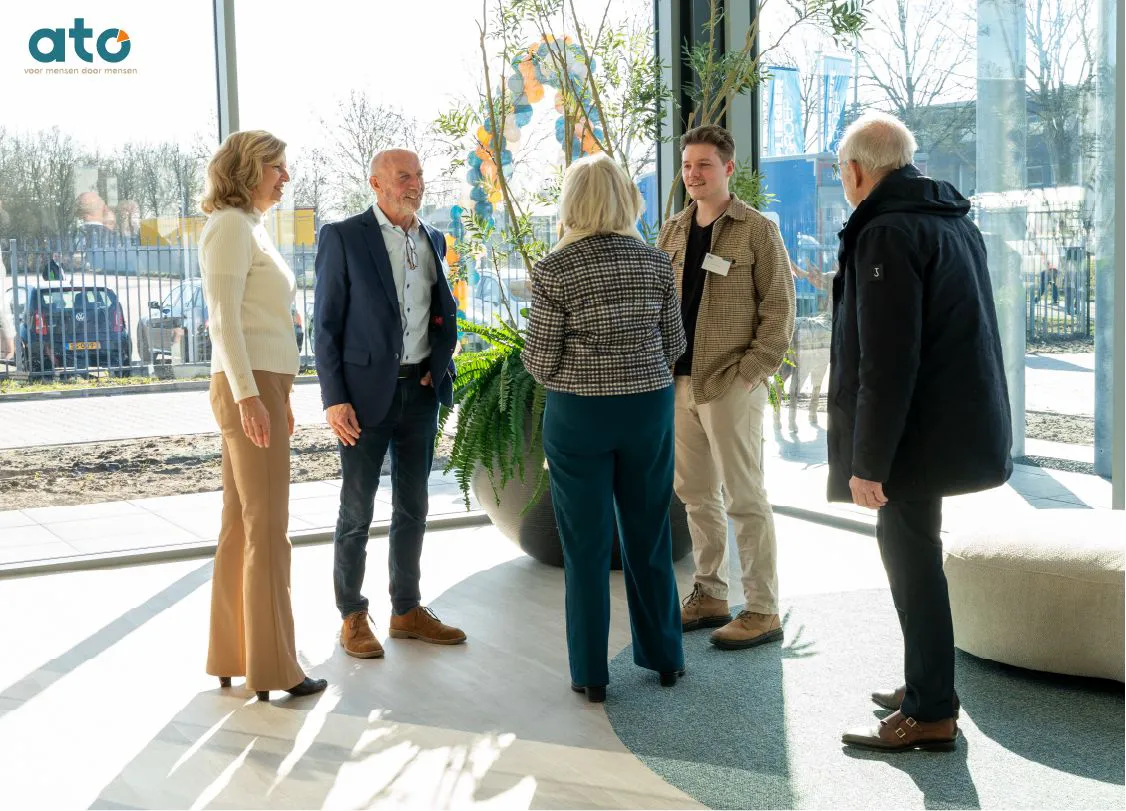 Open dag 14 februari. Een gezelschap staat te praten bij de entree van ATO. Samen gebouwd, samen gevierd.