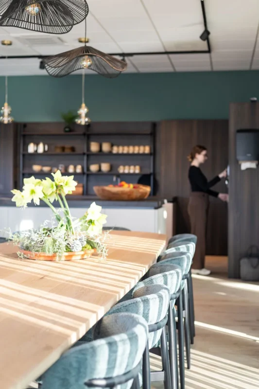 MVO bij ATO, pijler 5 Samenwerking en verantwoorde ketens. Op de foto is de kantine, op de achtergrond staat iemand bij koffie automaat in de keuken.