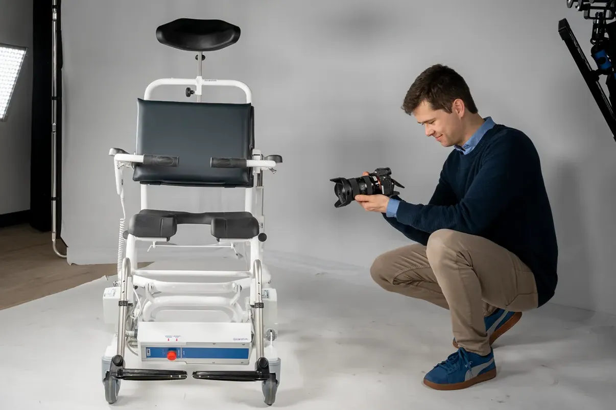 Achter de schermen: fotograaf maakt in een studio een productfoto van een elektrisch verstelbare douche-toiletstoel